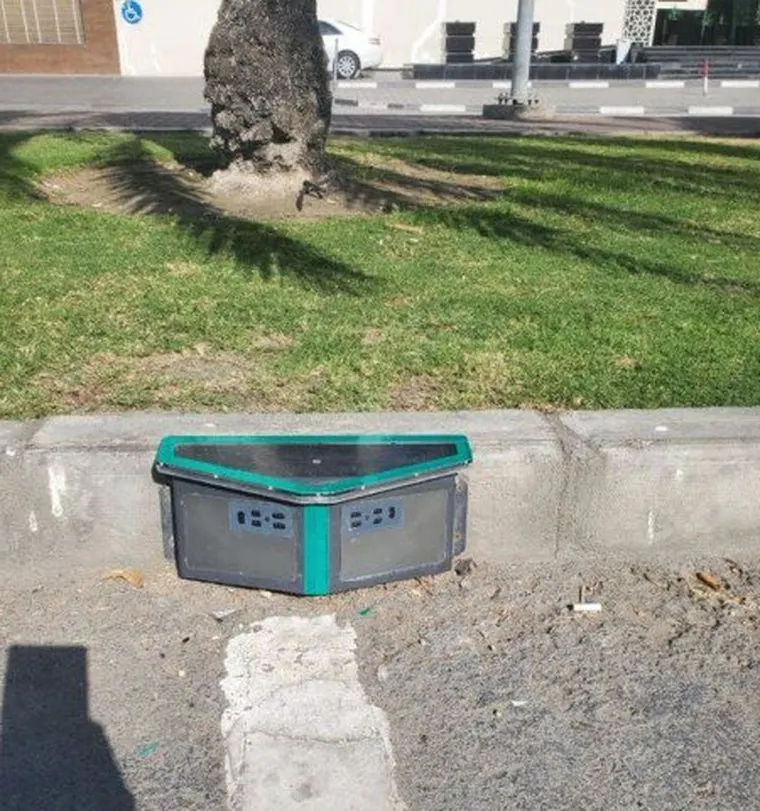 A kerbside sensor installed beside a shaded verge on an Omani street